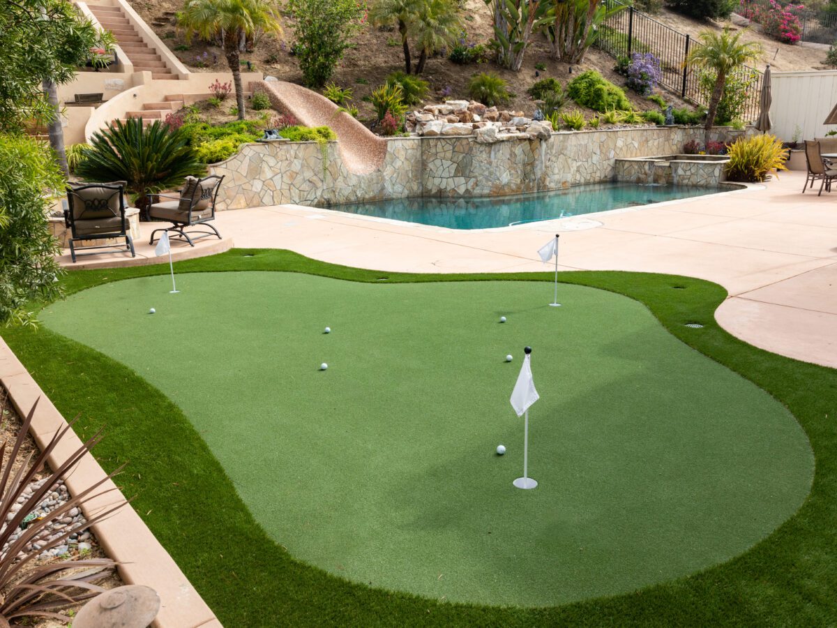putting green on a residential property with a beautiful water installation